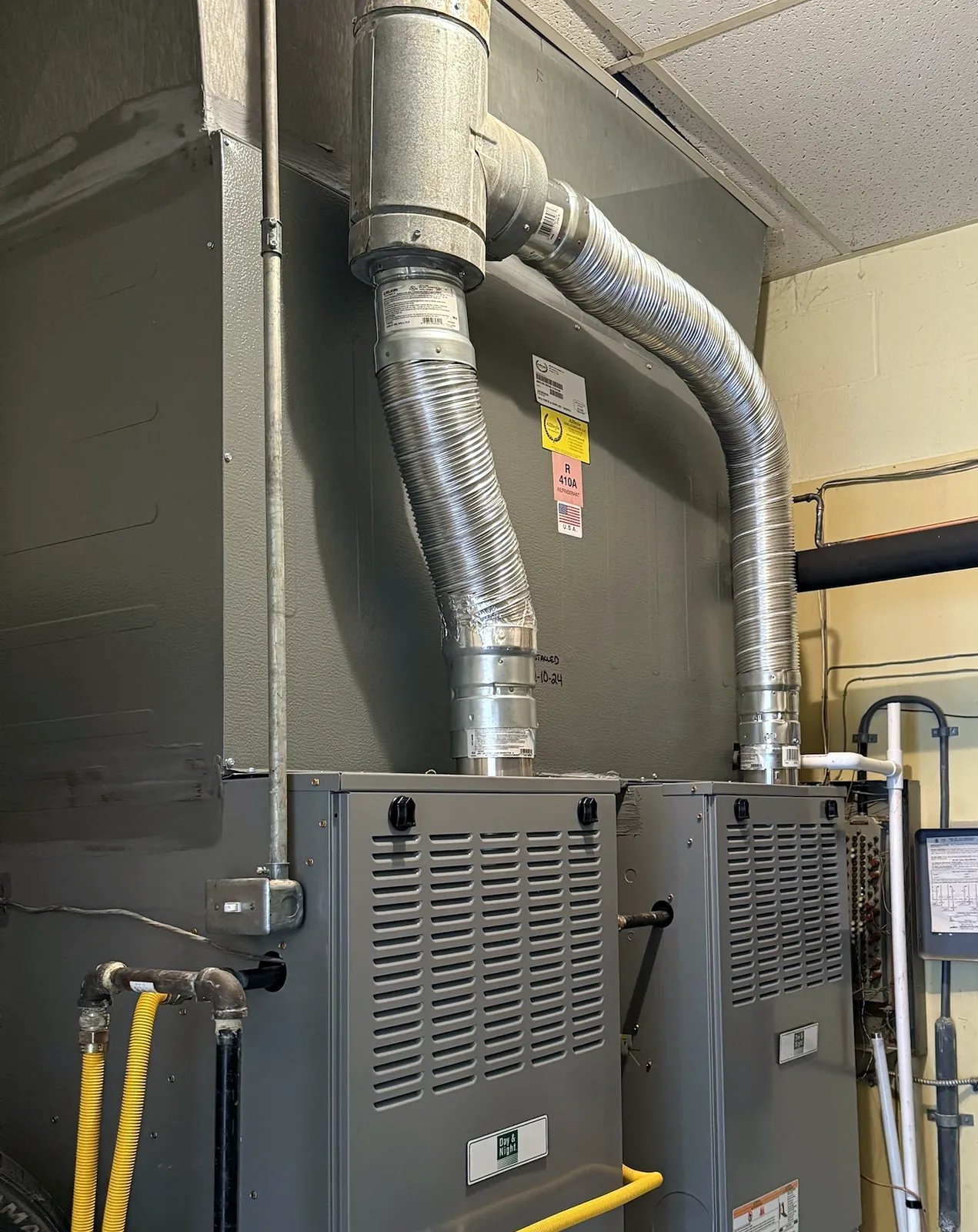 Two new Day & Night gas furnaces installed side by side with new venting
