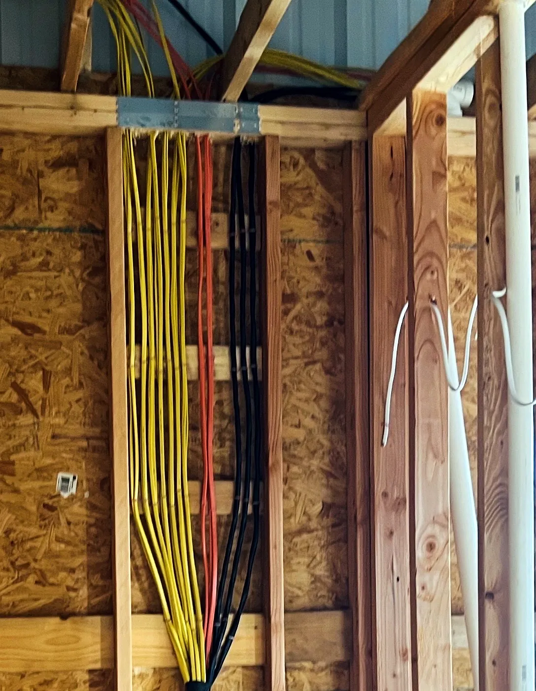 Neatly bundled home-run wiring in a new construction wall