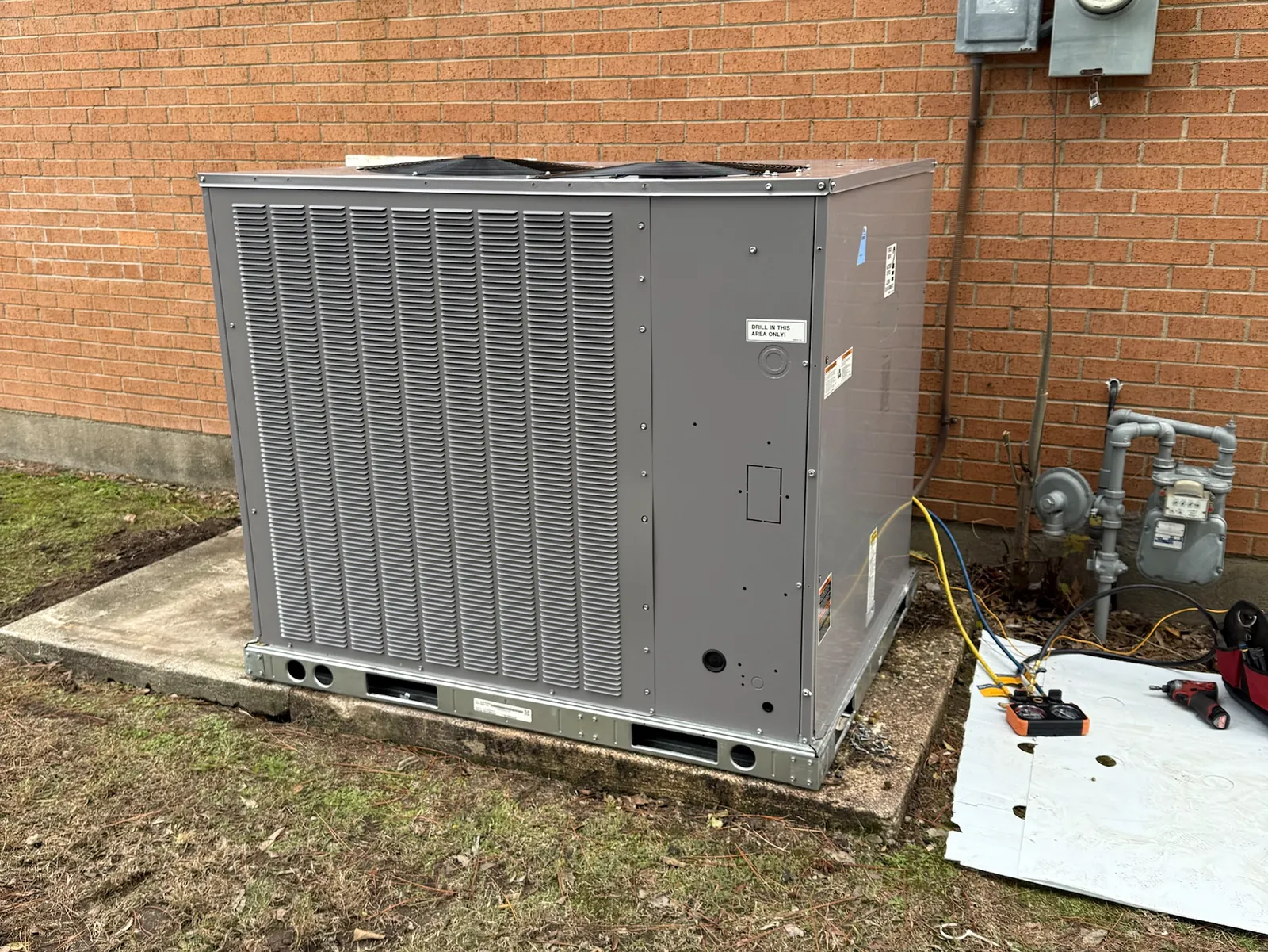 New gas/electric package unit installed beside a brick building